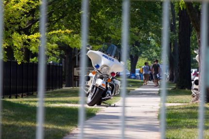 Police motorcycle seen through barricade