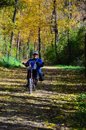 Recumbent bike rider on leaf covered trail